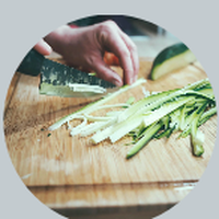 Fresh leeks being sliced on a wooden cutting board