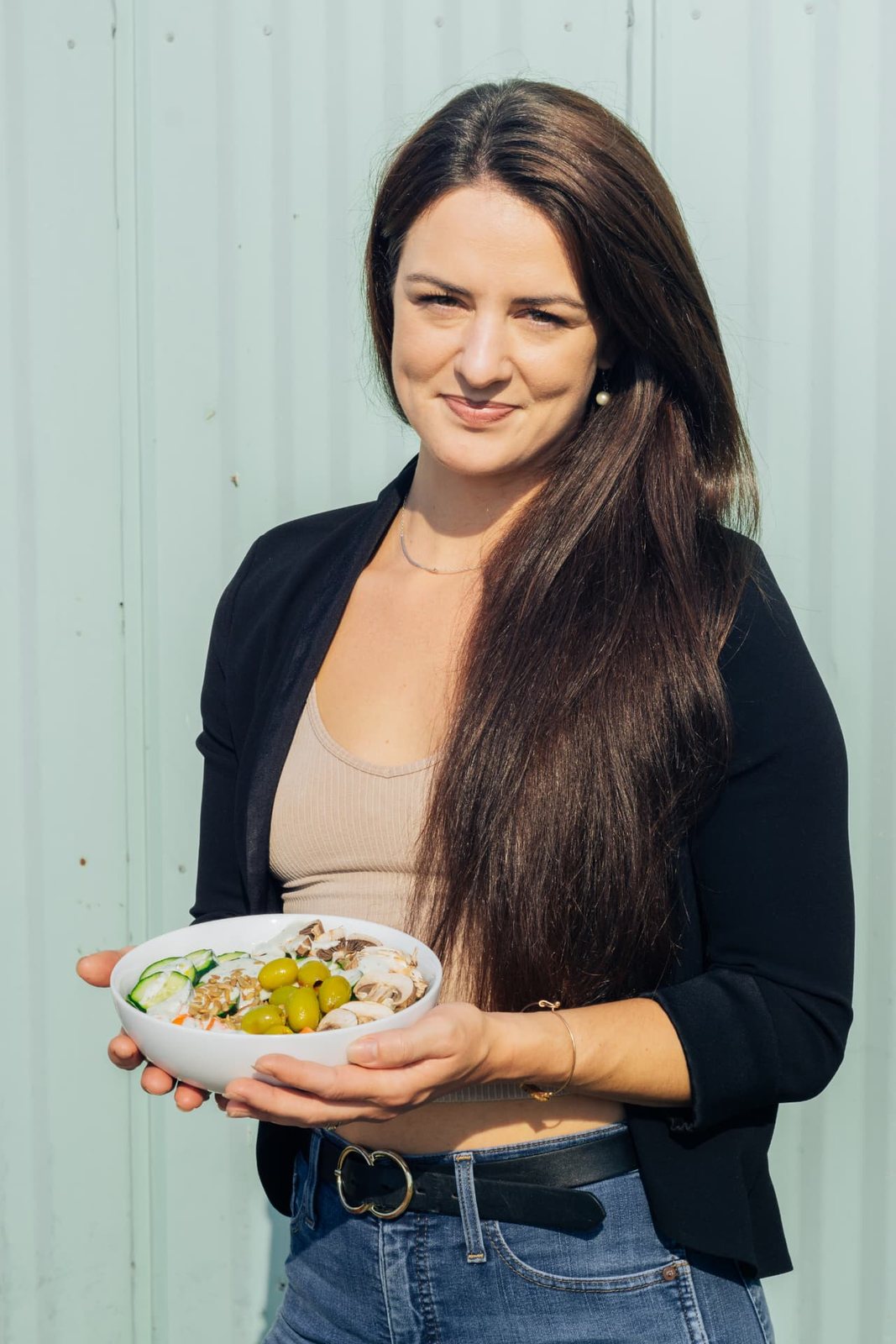 Ceylon Rose holding a bowl of fresh vegetables, smiling at the camera